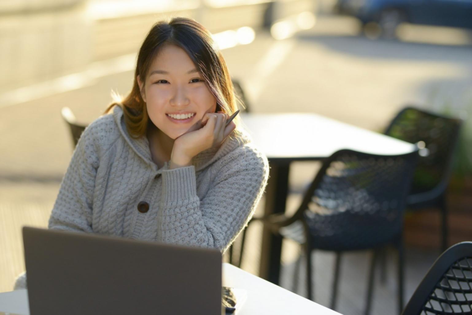 Studente che lavora alla creazione di un sito web su laptop con codice visibile sullo schermo